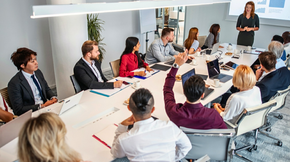 Abigail Merrill leading an AI workshop with a client team around a conference table